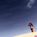 Nude young woman wearing a hat in the desert Merzouga Morocco stock photo