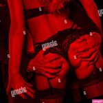 Rich man grab sexy blonde lover ass at nightclub in red light closeup Stock Photo