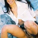 Dark-haired Latina exposes her slightly hairy pussy while on the rocks